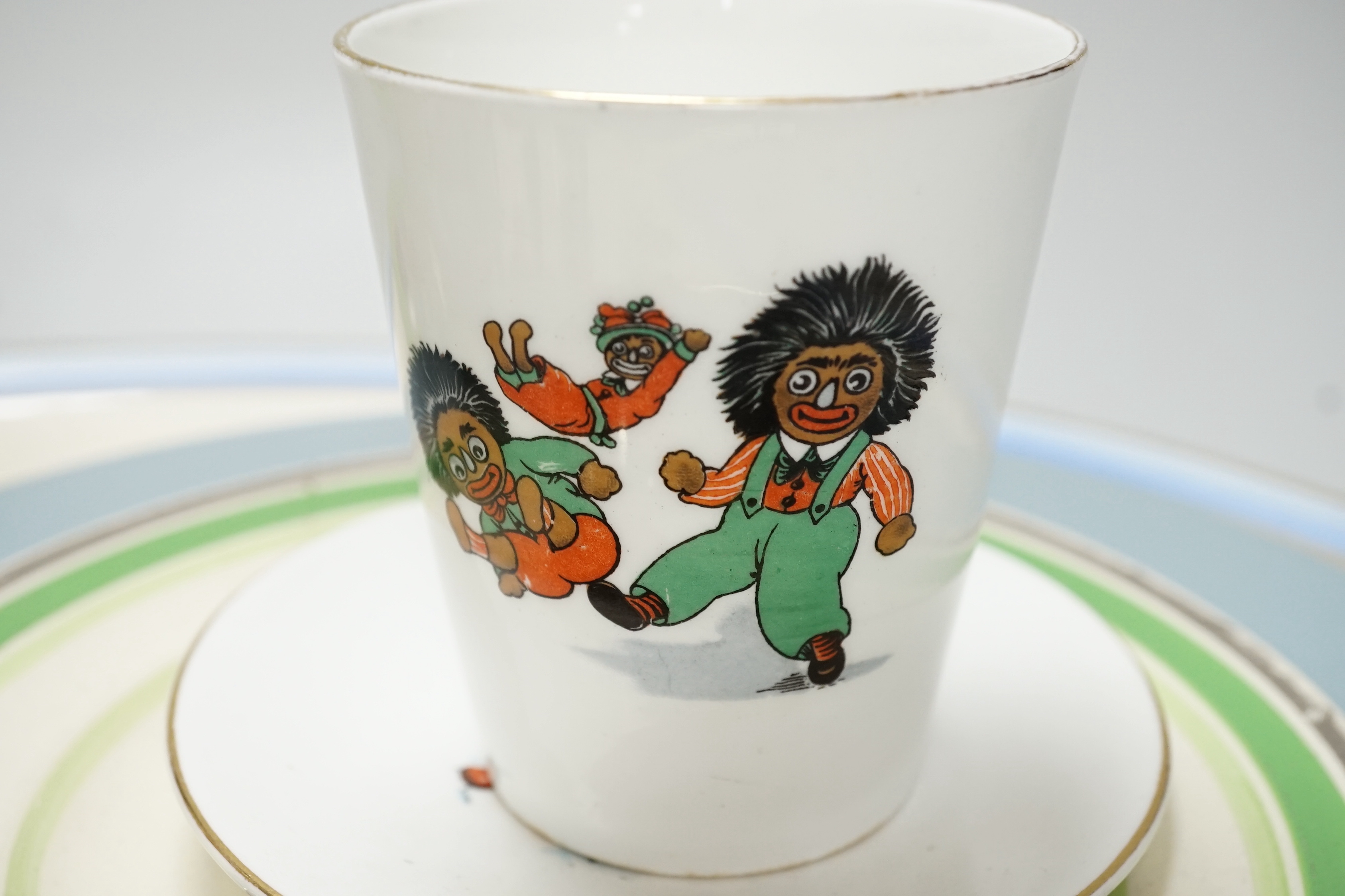 A quantity of golly china to include early green golly and a wooden doll part tea set